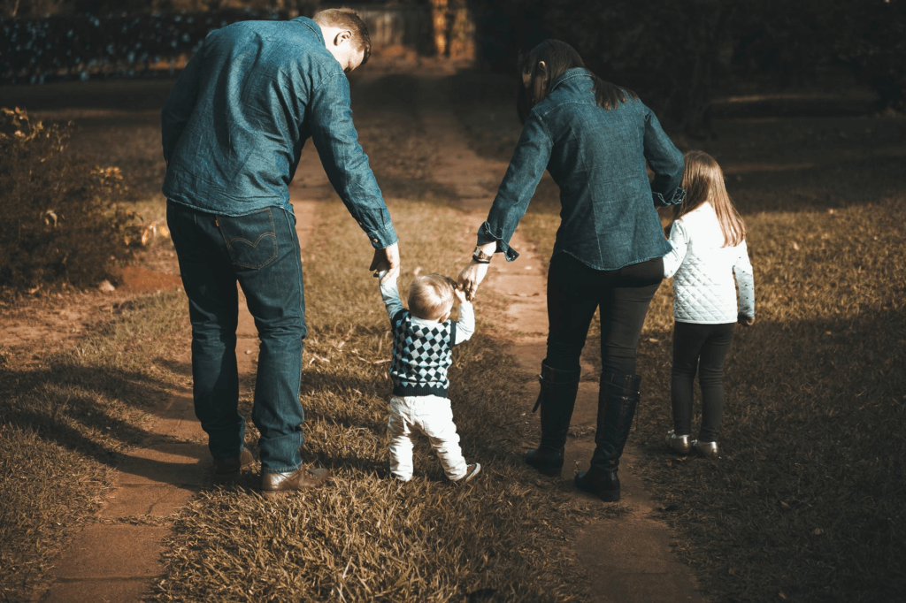 A Couple Helping Their Baby To Walk