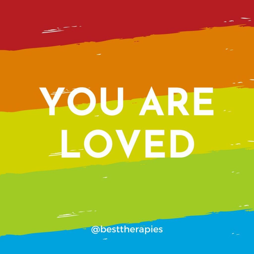 Red, orange, yellow, green and blue colored stripes in the background. The words "You are Loved" in white centered over the background.