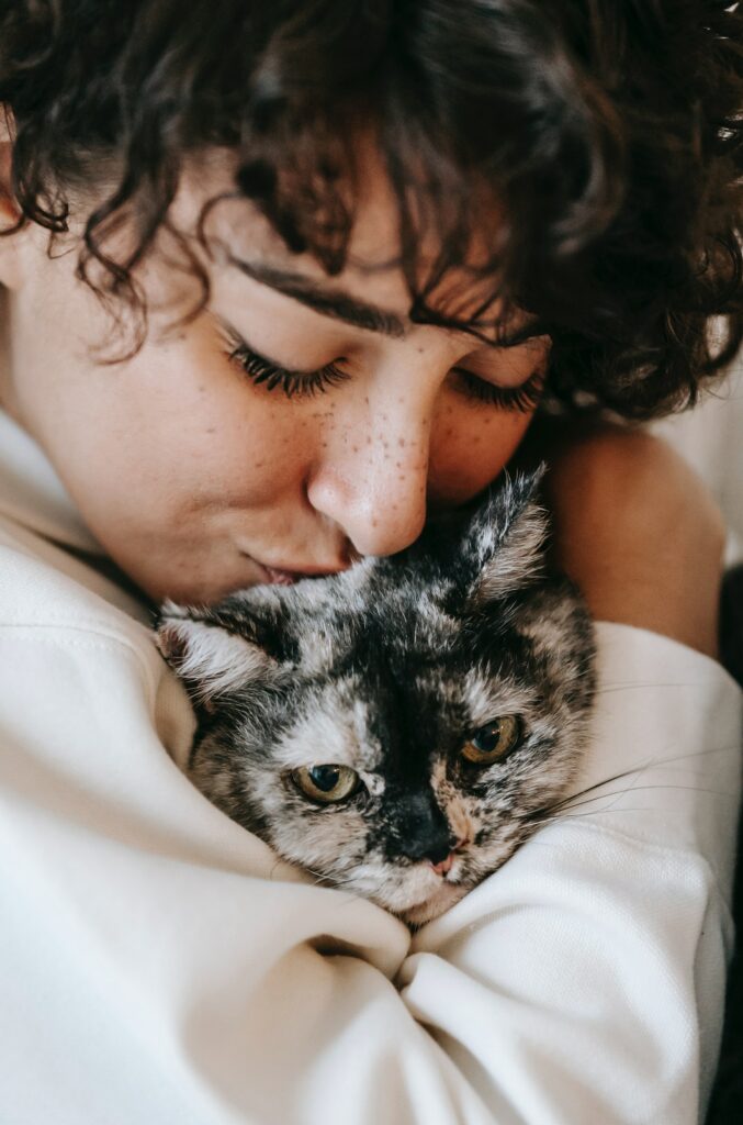 A woman cuddles a pet.